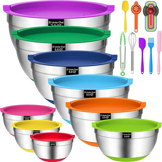 Set of stainless steel mixing bowls with colorful lids and kitchen utensils on a white background