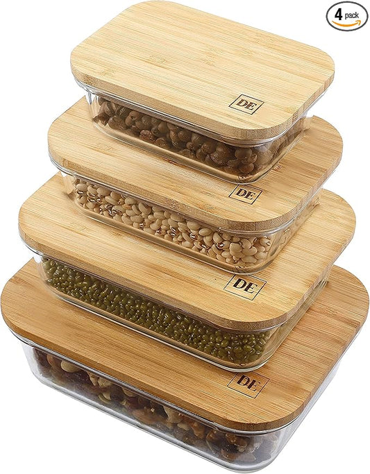 Set of four bamboo food storage containers with clear lids on a white background